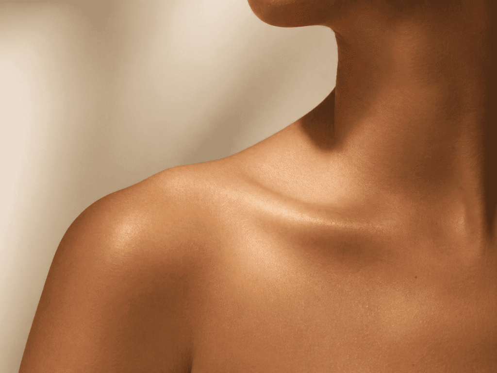 Close-up of a person's bare back and shoulder under soft lighting, evoking calm, vulnerability, and the physical weight of emotional stress.
